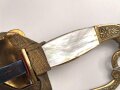 Bayern Beamtendegen. Sehr gut erhaltene Klinge mit beidseitiger Ätzung, die Lederscheide leicht geschrumpft. Die hintere Perlmuttgriffschale alt geklebt, das gefäß sonst gut. Mit dem eher seltenen Portepee