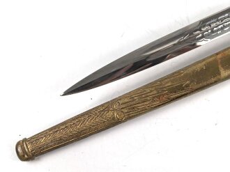 Dolch für Offiziere der Kriegsmarine. Saubere, doppelseitig geätzte Klinge von WKC. Blitzscheide ohne nennswerte Dellen mit ordentlicher Vergoldung. Original gewickeltes Portepee, zusammengehöriges Gehänge.
