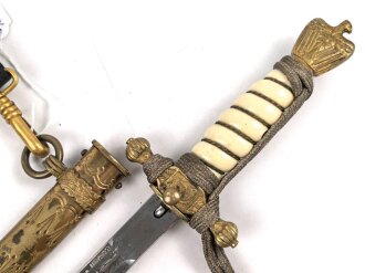 Dolch für Offiziere der Kriegsmarine. Saubere, doppelseitig geätzte Klinge von WKC. Blitzscheide ohne nennswerte Dellen mit ordentlicher Vergoldung. Original gewickeltes Portepee, zusammengehöriges Gehänge.