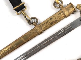 Dolch für Offiziere der Kriegsmarine. Saubere, doppelseitig geätzte Klinge von WKC. Blitzscheide ohne nennswerte Dellen mit ordentlicher Vergoldung. Original gewickeltes Portepee, zusammengehöriges Gehänge.
