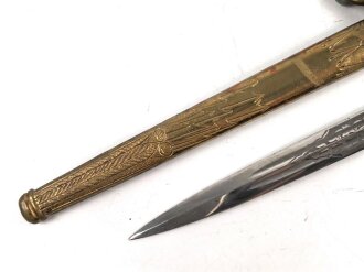 Dolch für Offiziere der Kriegsmarine. Saubere, doppelseitig geätzte Klinge von WKC. Blitzscheide ohne nennswerte Dellen mit ordentlicher Vergoldung. Original gewickeltes Portepee, zusammengehöriges Gehänge.