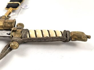 Dolch für Offiziere der Kriegsmarine. Saubere, doppelseitig geätzte Klinge von WKC. Blitzscheide ohne nennswerte Dellen mit ordentlicher Vergoldung. Original gewickeltes Portepee, zusammengehöriges Gehänge.
