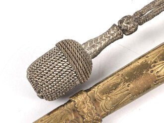 Dolch für Offiziere der Kriegsmarine. Saubere, doppelseitig geätzte Klinge von WKC. Blitzscheide ohne nennswerte Dellen mit ordentlicher Vergoldung. Original gewickeltes Portepee, zusammengehöriges Gehänge.