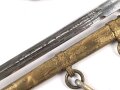 Dolch für Offiziere der Kriegsmarine. Saubere, doppelseitig geätzte Klinge von WKC. Blitzscheide ohne nennswerte Dellen mit ordentlicher Vergoldung. Original gewickeltes Portepee, zusammengehöriges Gehänge.