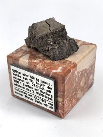 Bombensplitter auf neuzeitlicher Montierung, Laut Beschriftung aus Hamburg vom Februat 1945. Große des Splitters etwa 3 x 3 x 2cm