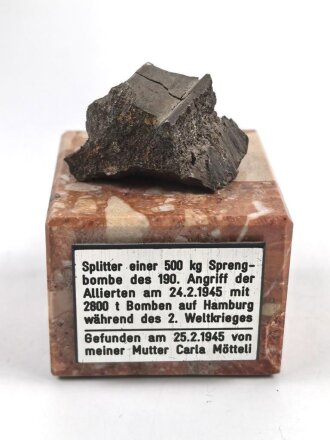 Bombensplitter auf neuzeitlicher Montierung, Laut Beschriftung aus Hamburg vom Februat 1945. Große des Splitters etwa 3 x 3 x 2cm