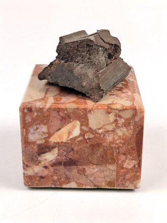Bombensplitter auf neuzeitlicher Montierung, Laut Beschriftung aus Hamburg vom Februat 1945. Große des Splitters etwa 3 x 3 x 2cm
