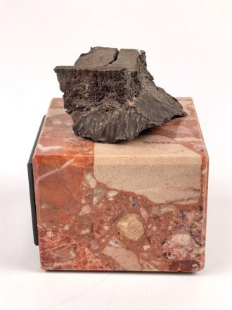 Bombensplitter auf neuzeitlicher Montierung, Laut Beschriftung aus Hamburg vom Februat 1945. Große des Splitters etwa 3 x 3 x 2cm