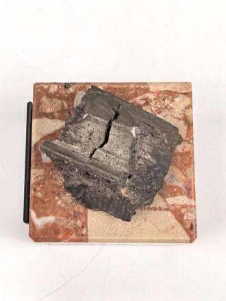 Bombensplitter auf neuzeitlicher Montierung, Laut Beschriftung aus Hamburg vom Februat 1945. Große des Splitters etwa 3 x 3 x 2cm