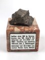 Bombensplitter auf neuzeitlicher Montierung, Laut Beschriftung aus Hamburg vom Februat 1945. Große des Splitters etwa 3 x 3 x 2cm
