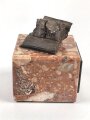 Bombensplitter auf neuzeitlicher Montierung, Laut Beschriftung aus Hamburg vom Februat 1945. Große des Splitters etwa 3 x 3 x 2cm