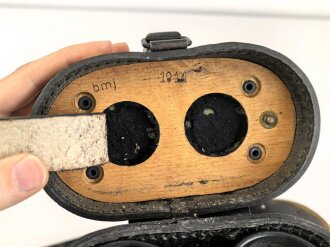 Dienstglas DF 10 x 50 Wehrmacht, sandfarbener Originallack, " kurze Variante" von bmj. Klare Durchsicht, an zugehörigem Trageriemen, in behälter aus Ersatzmaterial, dieser ebenfalls mit zugehörigem Trageriemen