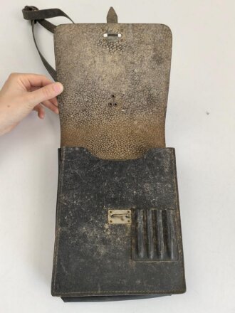 DDR, frühe Kartentasche aus genarbtem Leder, mit Trageriemen. Ungereinigtes Stück