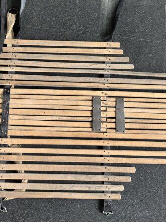 Vorrichtung zum bergen Verwundeter im Gebirge. Die Holzlattung mittig 132cm lang. Sowohl zum hinterherziehen im Schnee als auch zum Abseilen gedacht. Ungereinigtes Stück