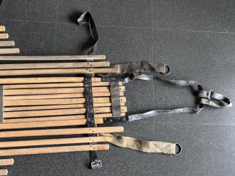 Vorrichtung zum bergen Verwundeter im Gebirge. Die Holzlattung mittig 132cm lang. Sowohl zum hinterherziehen im Schnee als auch zum Abseilen gedacht. Ungereinigtes Stück