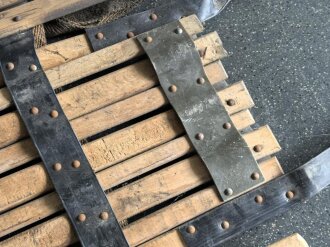 Vorrichtung zum bergen Verwundeter im Gebirge. Die Holzlattung mittig 132cm lang. Sowohl zum hinterherziehen im Schnee als auch zum Abseilen gedacht. Ungereinigtes Stück