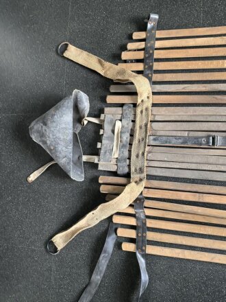 Vorrichtung zum bergen Verwundeter im Gebirge. Die Holzlattung mittig 132cm lang. Sowohl zum hinterherziehen im Schnee als auch zum Abseilen gedacht. Ungereinigtes Stück