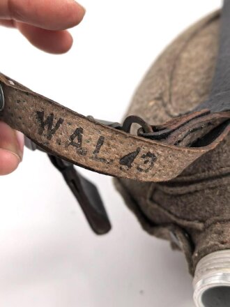 Feldflasche Wehrmacht, Hersteller WAL, belederung unten defekt, sonst sehr guter Zustand, mit zugehöriger Aufschiebeschlaufe. Variante mit grünmeliertem Preßmasse Trinkbecher