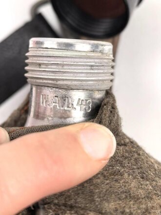 Feldflasche Wehrmacht, Hersteller WAL, belederung unten defekt, sonst sehr guter Zustand, mit zugehöriger Aufschiebeschlaufe. Variante mit grünmeliertem Preßmasse Trinkbecher