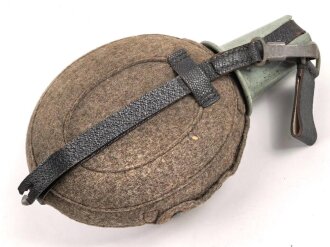 Feldflasche Wehrmacht, Hersteller WAL, belederung unten defekt, sonst sehr guter Zustand, mit zugehöriger Aufschiebeschlaufe. Variante mit grünmeliertem Preßmasse Trinkbecher