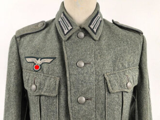 Heer, Feldbluse Modell 1940 für einen Obergefreiten der Kraftfahrtruppe. Leicht getragenes Kammerstück von 1941 . Die Kragenspiegel maschinenvernäht, der Brustadler von Hand. Im Rückenbereich diverse kleinere Schäden, sonst gut