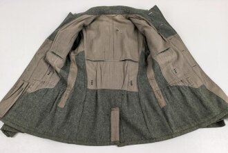Heer, Feldbluse Modell 1940 für einen Obergefreiten der Kraftfahrtruppe. Leicht getragenes Kammerstück von 1941 . Die Kragenspiegel maschinenvernäht, der Brustadler von Hand. Im Rückenbereich diverse kleinere Schäden, sonst gut