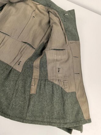 Heer, Feldbluse Modell 1940 für einen Obergefreiten der Kraftfahrtruppe. Leicht getragenes Kammerstück von 1941 . Die Kragenspiegel maschinenvernäht, der Brustadler von Hand. Im Rückenbereich diverse kleinere Schäden, sonst gut
