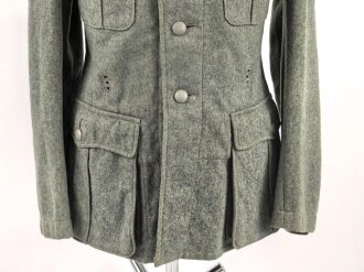 Heer, Feldbluse Modell 1940 für einen Obergefreiten der Kraftfahrtruppe. Leicht getragenes Kammerstück von 1941 . Die Kragenspiegel maschinenvernäht, der Brustadler von Hand. Im Rückenbereich diverse kleinere Schäden, sonst gut