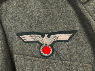 Heer, Feldbluse Modell 1940 für einen Obergefreiten der Kraftfahrtruppe. Leicht getragenes Kammerstück von 1941 . Die Kragenspiegel maschinenvernäht, der Brustadler von Hand. Im Rückenbereich diverse kleinere Schäden, sonst gut