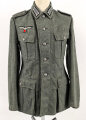 Heer, Feldbluse Modell 1940 für einen Obergefreiten der Kraftfahrtruppe. Leicht getragenes Kammerstück von 1941 . Die Kragenspiegel maschinenvernäht, der Brustadler von Hand. Im Rückenbereich diverse kleinere Schäden, sonst gut