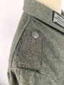 Heer, Feldbluse Modell 1940 für einen Obergefreiten der Kraftfahrtruppe. Leicht getragenes Kammerstück von 1941 . Die Kragenspiegel maschinenvernäht, der Brustadler von Hand. Im Rückenbereich diverse kleinere Schäden, sonst gut