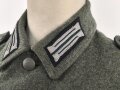 Heer, Feldbluse Modell 1940 für einen Obergefreiten der Kraftfahrtruppe. Leicht getragenes Kammerstück von 1941 . Die Kragenspiegel maschinenvernäht, der Brustadler von Hand. Im Rückenbereich diverse kleinere Schäden, sonst gut