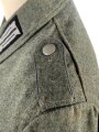 Heer, Feldbluse Modell 1940 für einen Obergefreiten der Kraftfahrtruppe. Leicht getragenes Kammerstück von 1941 . Die Kragenspiegel maschinenvernäht, der Brustadler von Hand. Im Rückenbereich diverse kleinere Schäden, sonst gut