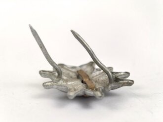 Traditionsedelweiss für die Schirmmütze von Angehörigen der gebirgstruppe der Wehrmacht. Wird zwischen Eichenlaub und Adler getragen. Fertigung aus Leichtmetall