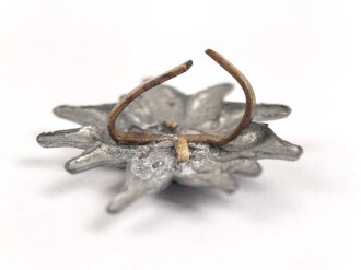 Traditionsedelweiss für die Schirmmütze von Angehörigen der Gebirgstruppe der Wehrmacht. Wird zwischen Eichenlaub und Adler getragen. Fertigung aus Zink, versilbert