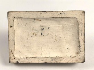 Erinnerungsgegenstand aus Giesmasse, Darstellend einen Stahlhelm des Heeres samt Ausrüstung für einen Infanteristen. Maße 8,5 x 12cm. Ungereinigtes Stück