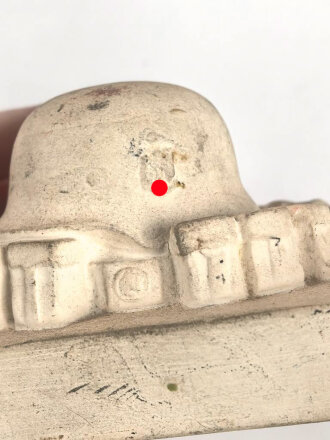 Erinnerungsgegenstand aus Giesmasse, Darstellend einen Stahlhelm des Heeres samt Ausrüstung für einen Infanteristen. Maße 8,5 x 12cm. Ungereinigtes Stück