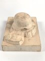 Erinnerungsgegenstand aus Giesmasse, Darstellend einen Stahlhelm des Heeres samt Ausrüstung für einen Infanteristen. Maße 8,5 x 12cm. Ungereinigtes Stück