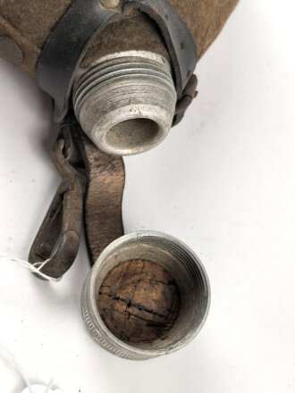 2.Weltkrieg, Feldflasche Modell 1910, der Schraubdeckel datiert 1915. Gegen Ende des 2. Weltkriegs reaktiviert, mit neuem Bezug und Belederung versehen und nochmals verausgabt. Ungereinigtes Stück, Leder trocken