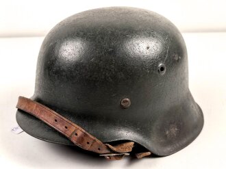 Stahlhelm Wehrmacht Modell 1942. Vermutlich nach dem Krieg von einer österreichischen Polizei ? Einheit weitergetragen. Im Zuge dessen wurde das Leder im Innenfutter sowie der Kinnriemen erneuert.  Mehrfach überlackiert, kein Hersteller erkennbar.