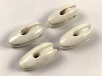 Vier Isolatoren aus weissem Porzellan. Kleinere, schmale Ausführung, sieht man so bei Flugzeugen
