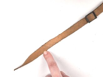 Kinnriemen für einen Tropenhelm der Wehrmacht. An der Befestigung ausgerissen, Gesamtlänge wie fotografiert 46cm. Ungereinigt