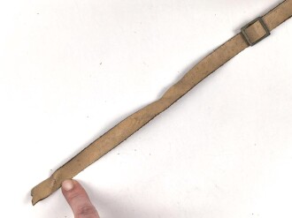 Kinnriemen für einen Tropenhelm der Wehrmacht. An der Befestigung ausgerissen, Gesamtlänge wie fotografiert 45cm. Ungereinigt, leicht angetrocknet
