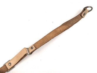 Kinnriemen für einen Tropenhelm der Wehrmacht. An der Befestigung ausgerissen, Gesamtlänge wie fotografiert 45cm. Ungereinigt, leicht angetrocknet
