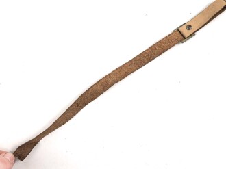 Kinnriemen für einen Tropenhelm der Wehrmacht. An der Befestigung ausgerissen, Gesamtlänge wie fotografiert 45cm. Ungereinigt, leicht angetrocknet