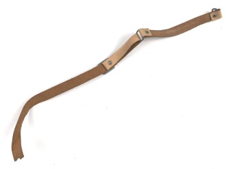 Kinnriemen für einen Tropenhelm der Wehrmacht. An der Befestigung ausgerissen, Gesamtlänge wie fotografiert 45cm. Ungereinigt, leicht angetrocknet