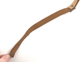 Kinnriemen für einen Tropenhelm der Wehrmacht. An der Befestigung ausgerissen, Gesamtlänge wie fotografiert 45cm. Ungereinigt, leicht angetrocknet