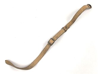 Kinnriemen für einen Tropenhelm der Wehrmacht. An der Befestigung ausgerissen, Gesamtlänge wie fotografiert 44cm. Ungereinigt, leicht angetrocknet