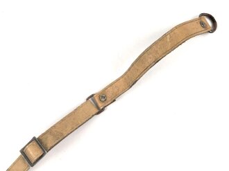 Kinnriemen für einen Tropenhelm der Wehrmacht. An der Befestigung ausgerissen, Gesamtlänge wie fotografiert 44cm. Ungereinigt, leicht angetrocknet
