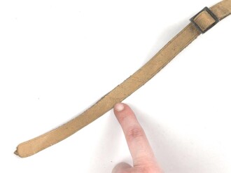 Kinnriemen für einen Tropenhelm der Wehrmacht. An der Befestigung ausgerissen, Gesamtlänge wie fotografiert 44cm. Ungereinigt, leicht angetrocknet
